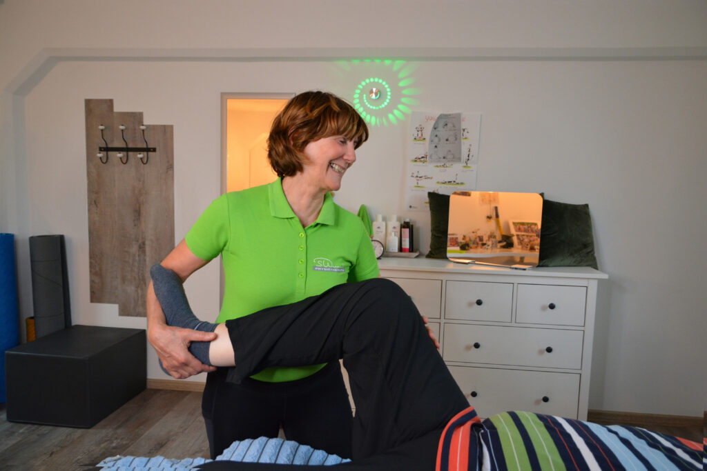 Physiotherapeuten behandelt am rechten Bein